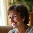 Donna italiana di circa 38 anni con un'espressione serena e rilassata, seduta in un ambiente accogliente, con un leggero sorriso, a rappresentare la riduzione dell'ansia dopo la guarigione intestinale.