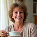 Donna italiana di circa 40 anni, sorridente e rilassata, che tiene una tazza di tè alle erbe, in un ambiente casalingo e luminoso, a simboleggiare la risoluzione dell'IBS.